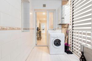 una lavadora y secadora blancas en una lavandería blanca en ARGANZUELA en Madrid