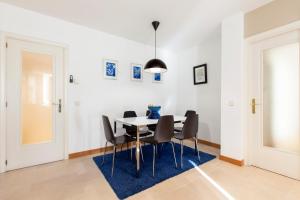 a dining room with a table and chairs on a blue rug at ARGANZUELA in Madrid