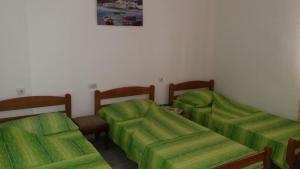 dwa łóżka w pokoju z zieloną pościelą w obiekcie Rooms Sijak w Barze
