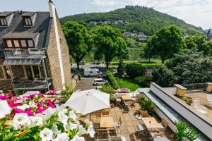 a balcony with tables and chairs and an umbrella at Villa Cuchema in Cochem