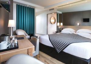 ブローニュ・ビヤンクールにあるHotel Acanthe - Boulogne Billancourtのベッドと机があるホテルの部屋