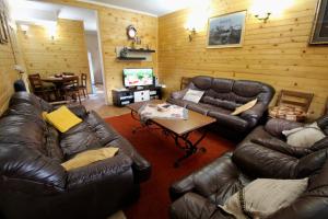 a living room with leather couches and a television at Mountain Family House Zara in Žabljak