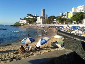 people on a beach with umbrellas and the ocean at Luiz & Cristiana Sampaio in Salvador +8 photos