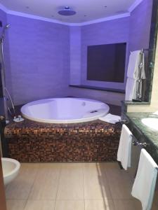 a bath tub sitting next to a toilet in a bathroom at Hotel Motel Luna in Segrate