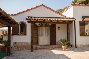 ein Haus mit Holztüren und einer Veranda in der Unterkunft Baglio Scurati in Custonaci