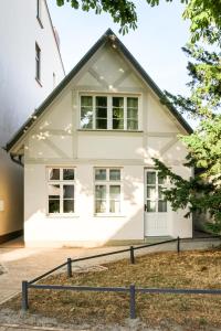 a white house with a black roof at Apartment in der Alexandrinenstrasse in Warnemünde
