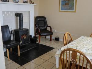a room with a stove and two chairs and a table at Killary Bay View House in Renvyle