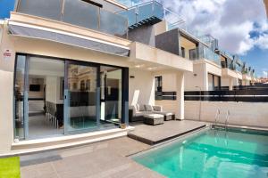 una casa con piscina frente a una casa en Casa Villamartin, en Villamartin