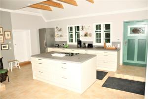 a large kitchen with white cabinets and a blue door at Alte Post, Liepe in Rankwitz