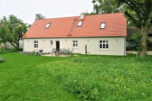 una casa blanca con techo naranja en un patio en Alte Post, Liepe, en Rankwitz