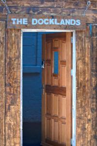 a wooden door with the doorkangs sign on it at The Docklands SA by Serviced Living Liverpool in Liverpool