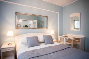 a bedroom with a bed with a mirror on the wall at Hotel Renusz in Gdańsk