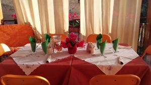 a table with a red table cloth and flowers on it at Montagne Rocciose in Frascineto