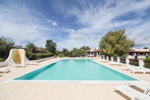 a pool at a resort with lounge chairs and a swimming pool at White Sand Residence in Murta Maria