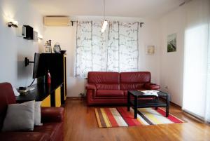 a living room with a red couch and a table at Family House Talani in Zagreb