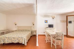 a bedroom with a bed and a table and a desk at White Sand Residence in Murta Maria
