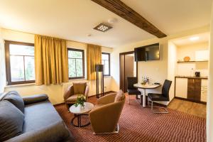 a living room with a couch and a table at Hotel Goldener Hirsch in Suhl