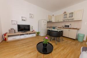 een grote woonkamer met een tafel en een keuken bij Apartman Jelena 2 in Kaštela