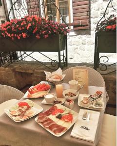 a table topped with plates of food and drinks at Hotel Villa Duomo in Kotor