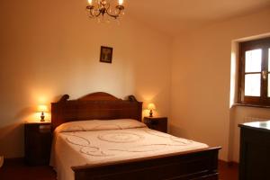 1 dormitorio con 1 cama con 2 mesitas de noche y una ventana en La Torre, en Castiglion Fiorentino