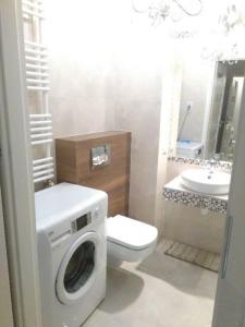 a bathroom with a washing machine and a sink at Manufaktura in Warsaw