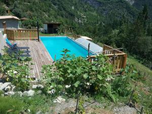 a swimming pool with a wooden deck next to a mountain at Mistoulin in Rigaud