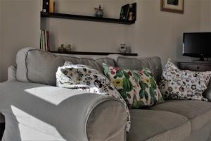 a couch with pillows on it in a living room at Le Case in Bevagna