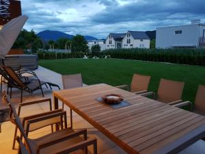 Une table et des chaises en bois sont disponibles sur la terrasse. dans l'établissement SPA-Lounge, à Seeboden