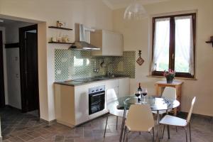 a kitchen with a table and a stove top oven at Le Case in Bevagna