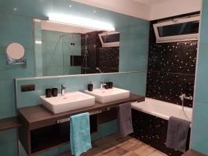 łazienka z 2 umywalkami, lustrem i wanną w obiekcie SPA-Lounge w mieście Seeboden