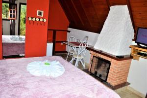 a room with a bed and a fireplace in a room at Chalés Fazenda das Samambaias in Monte Verde