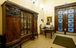 Cette chambre comprend un bureau et une grande armoire en bois. dans l'établissement Karoly Corner Residences, à Budapest