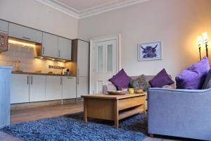 uma sala de estar com um sofá e uma mesa em Kirk View Apartment em Stirling