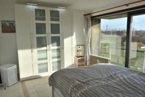 a bedroom with a bed and a large window at SunnySide-of-TheSea - stunning view on nature, big terraces all around - 150 m from sea, beach, stores, restaurants & beach bars - with parking in Nieuwpoort