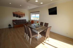 a dining room with a table and chairs and a couch at Torre Mar in Armação de Pêra