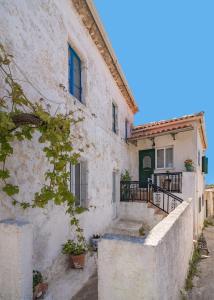 a white house with a staircase in front of it at Angel's House in Volímai