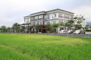 una casa grande con un campo de hierba delante de ella en Spring Fountain Hotel, en Jiaoxi