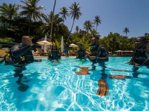 eine Gruppe von Personen, die im Pool im Wasser sitzen in der Unterkunft Club Santana Beach & Resort in SantʼAna