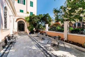 a courtyard with chairs and tables and a building at Hotel Miramare in Spotorno