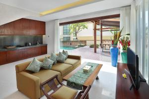 a living room with a couch and a table at The Miracle Villa Nusa Dua in Nusa Dua