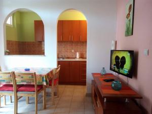 a kitchen and dining room with a table and a television at Apartman Bo&scaron;ković in Budva