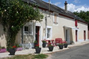 un edificio bianco con vasi di fiori di fronte di Chalet aux pied des vignes a Montigny