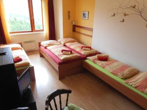 Habitación con 3 camas y TV. en Apartment Ramzová Adam 25 en Ramzová