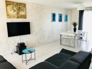 a living room with a couch and a table at CosyStudio2 Site du Futuroscope in Jaunay-Marigny