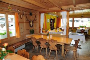 uma sala de jantar com uma mesa de madeira e cadeiras em Berggasthaus Gemsli em Sankt Antönien