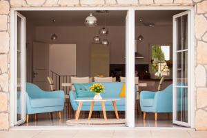 a living room with blue chairs and a table at Villa Dora in Sužan