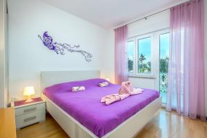 a bedroom with a bed with two stuffed animals on it at Apartman - The view in Krk