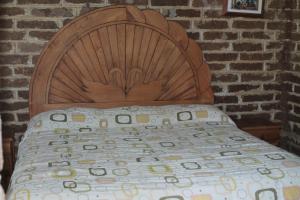 1 cama con cabecero de madera en un dormitorio en El Huariche, en Huasca de Ocampo