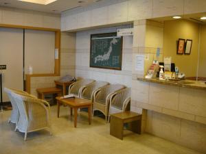 - une salle d'attente avec des chaises et un tableau noir sur le mur dans l'établissement Hotel Route-Inn Naha Asahibashi Eki Higashi, à Naha