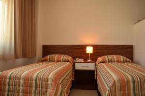 Un pat sau paturi într-o cameră la Hotel Flat Itaipava